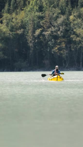 Människan paddlar på flotte båt i fjällsjön — Stockvideo