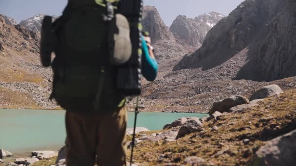 Túrázó turista hátizsákkal séta a hegyi tó közelében — Stock videók