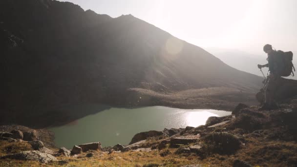 Wandertourist mit Rucksack wandert in der Nähe des Bergsees — Stockvideo