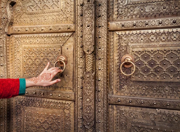 Женщина, открывающая золотую дверь в Джайпуре — стоковое фото