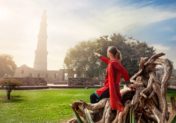 Žena ukazuje na Qutub Minar — Stock fotografie