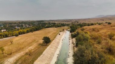Sonbahar zamanı Kazakistan 'ın Almaty şehrinde, sonbahar zamanı, yol kenarındaki tarlanın ve dağların yakınlarındaki büyük sulama alanının hava aracı manzarası.