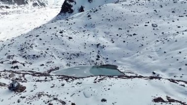 Bakir beyaz kar ve büyük buz buzullarıyla kaplı dağ sırtı manzarasının hava drone görüntüsü. Kazakistan 'ın Almaty şehrindeki Tien Shan Dağı