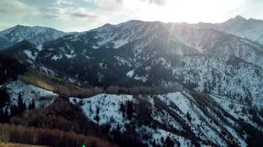 Dağ sırtı manzarasının havadan drone görüntüsü tepeler arasında saf beyaz karla kaplı. Kazakistan 'ın Almaty şehrindeki Tien Shan Dağı