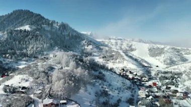 Dağ vadisi manzarasının insansız hava aracı görüntüsü bakire beyaz kar ve Kazakistan 'ın Almaty Şehri yakınlarındaki küçük köy hortumlarıyla kaplıydı.