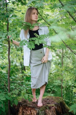 Meditasyon ve doğayla etkileşim pratiği. Yeşil ormandaki kız