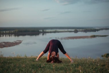Yoga pratiği ve güneş doğarken meditasyon. Kama nehrinin yanında alıştırma yapan kadın..