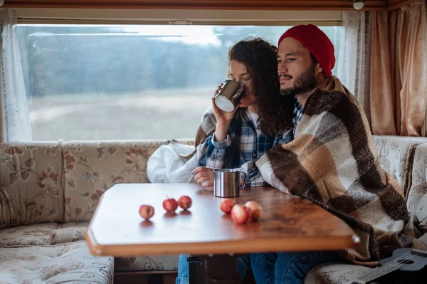 Couple assis à une table dans un camping-car et boire du thé. — Photo