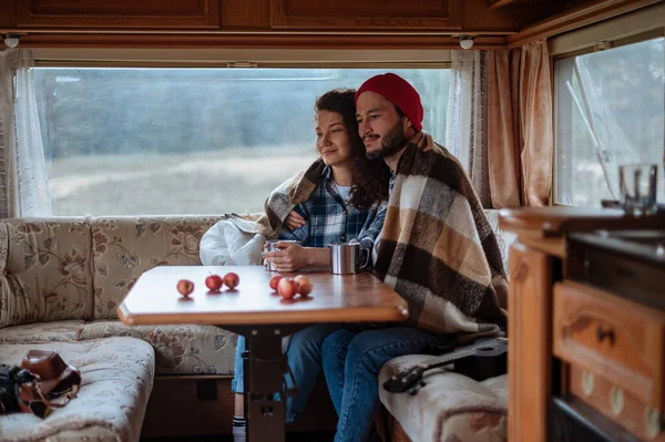 Couple assis à une table dans un camping-car et boire du thé. — Photo