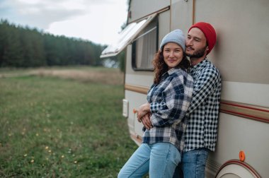 Romantik çift karavanın yanında birlikte vakit geçiriyorlar..