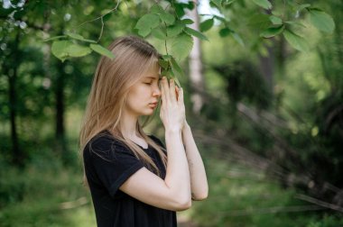 Meditasyon ve doğayla etkileşim pratiği. Yeşil ormandaki kız