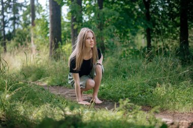 Meditasyon ve doğayla etkileşim pratiği. Yeşil ormandaki kız