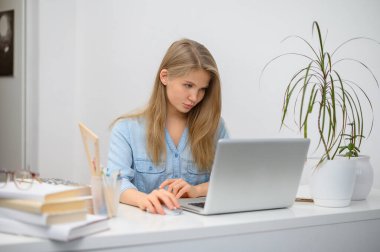 Bilgisayarlı bir kız çevrimiçi bir okulda okuyor. Beyaz oda arkaplanı