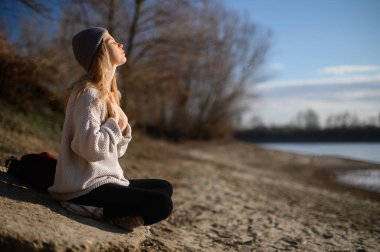 Meditasyon ve doğayla etkileşim pratiği. Nehir kenarındaki kız