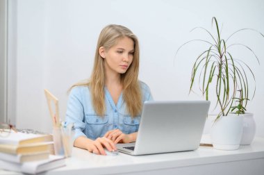 Bilgisayarlı bir kız çevrimiçi bir okulda okuyor. Beyaz oda arkaplanı