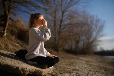 Meditasyon ve doğayla etkileşim pratiği. Nehir kenarındaki kız