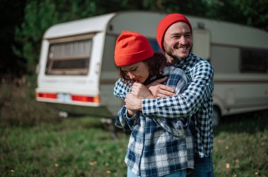 Romantik çift karavanın yanında birlikte vakit geçiriyorlar.