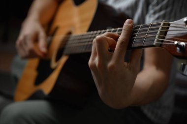 Akustik gitar çalan adam, çevrimiçi kursları kapsayan, evde öğrenim.