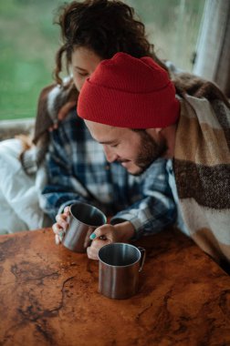 Karavanda bir masada oturan ve çay içen çift..