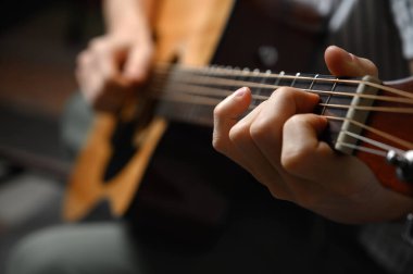 Akustik gitar çalan adam, çevrimiçi kursları kapsayan, evde öğrenim.