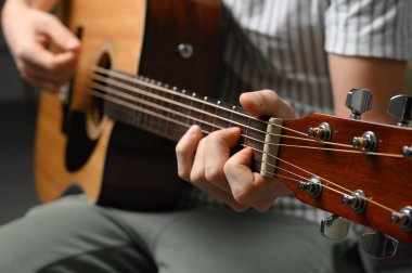 Akustik gitar çalan adam, çevrimiçi kursları kapsayan, evde öğrenim.