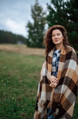 Kareli ekoseli bir çift, karavanın yanında lokum pişiriyor..