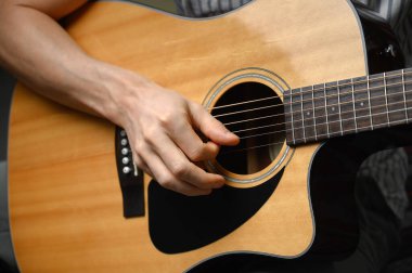 Akustik gitar çalan adam, çevrimiçi kursları kapsayan, evde öğrenim.