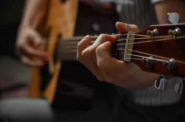 Akustik gitar çalan adam, çevrimiçi kursları kapsayan, evde öğrenim.