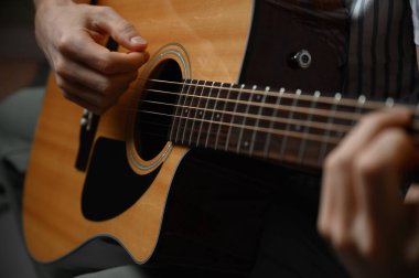 Akustik gitar çalan adam, çevrimiçi kursları kapsayan, evde öğrenim.