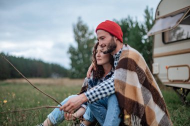 Romantik çift karavanın yanında birlikte vakit geçiriyorlar..