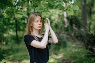 Meditasyon ve doğayla etkileşim pratiği. Yeşil ormandaki kız