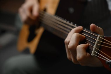 Akustik gitar çalan adam, çevrimiçi kursları kapsayan, evde öğrenim.