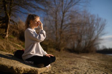 Meditasyon ve doğayla etkileşim pratiği. Nehir kenarındaki kız