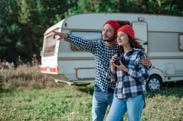 Couple romantique avec une caméra dans la nature près de la remorque à la maison. — Photo