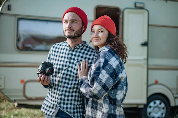 Couple romantique avec une caméra dans la nature près de la remorque à la maison. — Photo