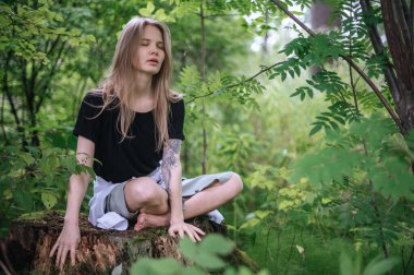 Meditasyon ve doğayla etkileşim pratiği. Yeşil ormandaki kız