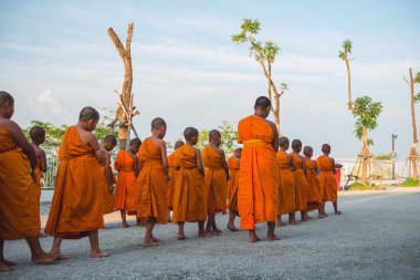 Tayland 'daki Phuket' teki Büyük Buda Tapınağı yakınlarında turuncu elbiseli genç Budistler. 28 Nisan 2019