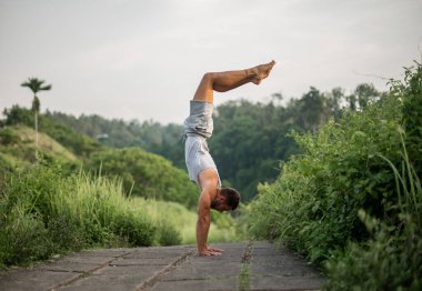 Erkek, dışarıda yoga ve meditasyon pratiği yapıyor.