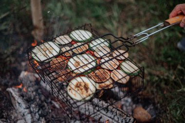 Assorted delicious grilled vegetables on barbecue grill with smoke and flames