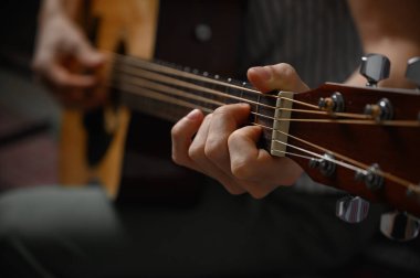 Akustik gitar çalan adam, çevrimiçi kursları kapsayan, evde öğrenim.