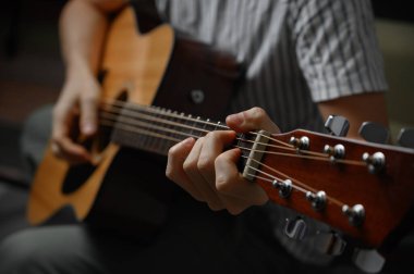 Akustik gitar çalan adam, çevrimiçi kursları kapsayan, evde öğrenim.