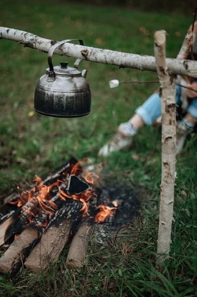 Fogueira perto da casa do reboque.Casal em um xadrez xadrez assando marshmallows — Fotografia de Stock