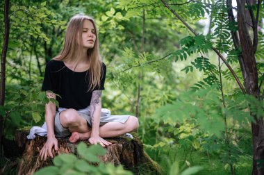 Meditasyon ve doğayla etkileşim pratiği. Yeşil ormandaki kız