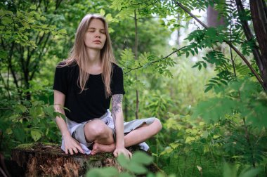 Meditasyon ve doğayla etkileşim pratiği. Yeşil ormandaki kız