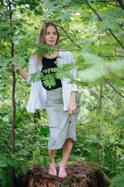 Meditasyon ve doğayla etkileşim pratiği. Yeşil ormandaki kız