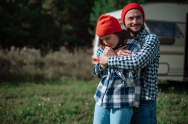 Romantik çift karavanın yanında birlikte vakit geçiriyorlar.