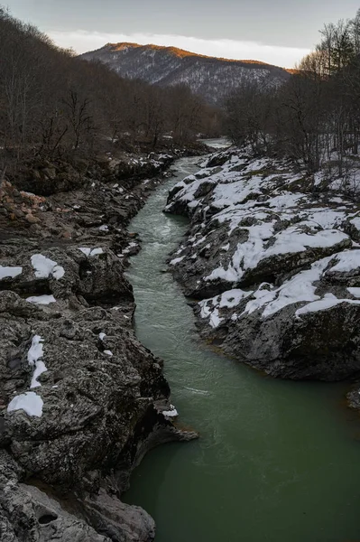 Fiume di montagna innevato al tramonto. Acqua di colore verde — Foto Stock