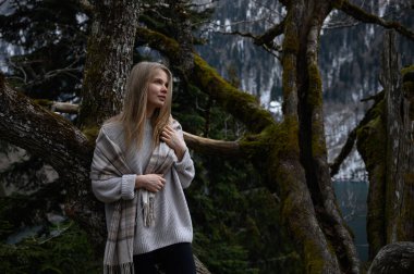 Kız ağaçta oturur ve Abhazya 'da Ritsa Gölü yakınlarında meditasyon yapar.