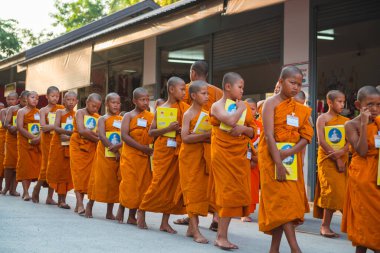 Tayland 'daki Phuket' teki Büyük Buda Tapınağı yakınlarında turuncu elbiseli genç Budistler. 28 Nisan 2019