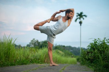 Erkek, dışarıda yoga ve meditasyon pratiği yapıyor.